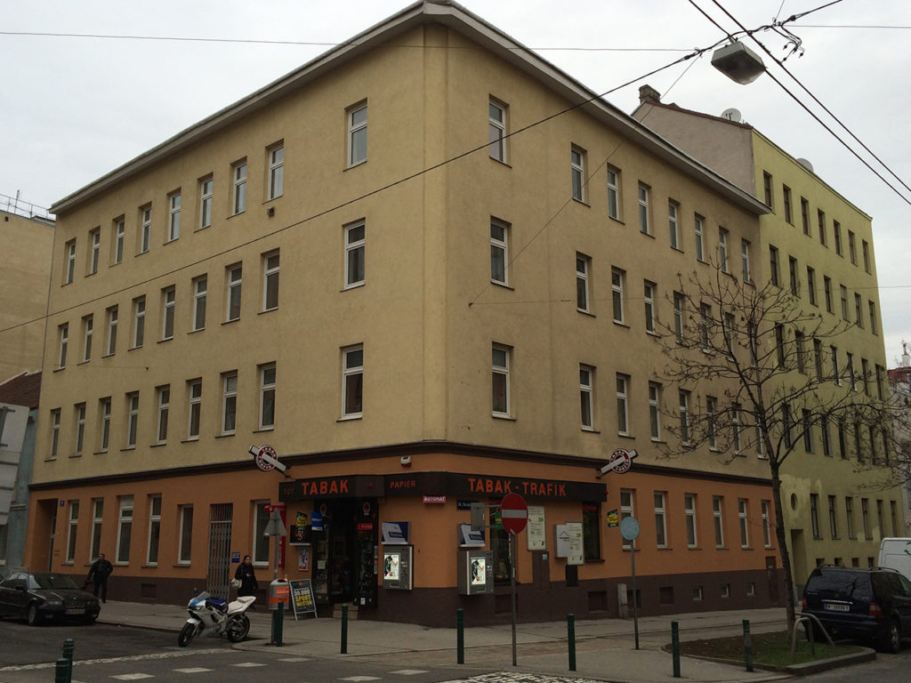 Eckhaus im 10. Bezirk Wiens, gelbe Fassade, mit Trafik im Erdgeschoss