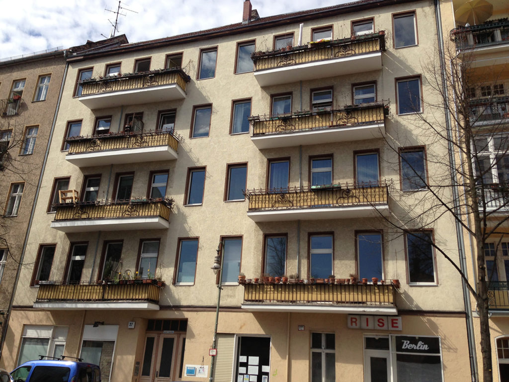 altes Wohnhaus in Berlin, mit Balkonen und beiger Fassade, Geschäftslokal im Erdgeschoß