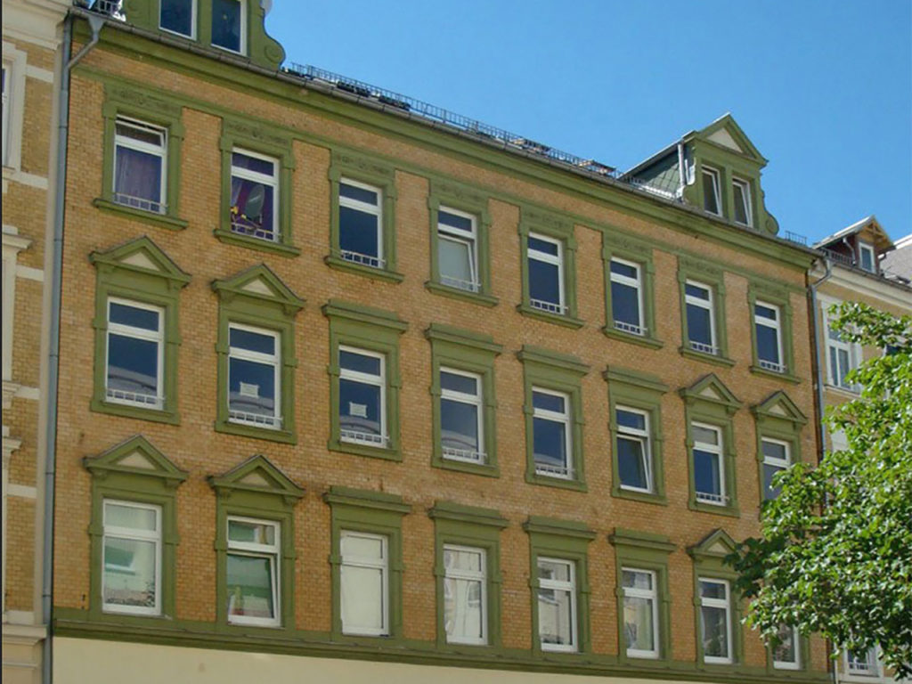 Zinhaus in Chemnitz, Fassade in heller Ziegeloptik, Fenster weiß mit grüner Verzierung