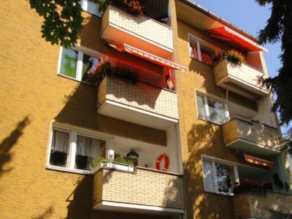 älteres Wohnhaus in Berlin, orange Fassade und weiße Fenster, mit Balkonen