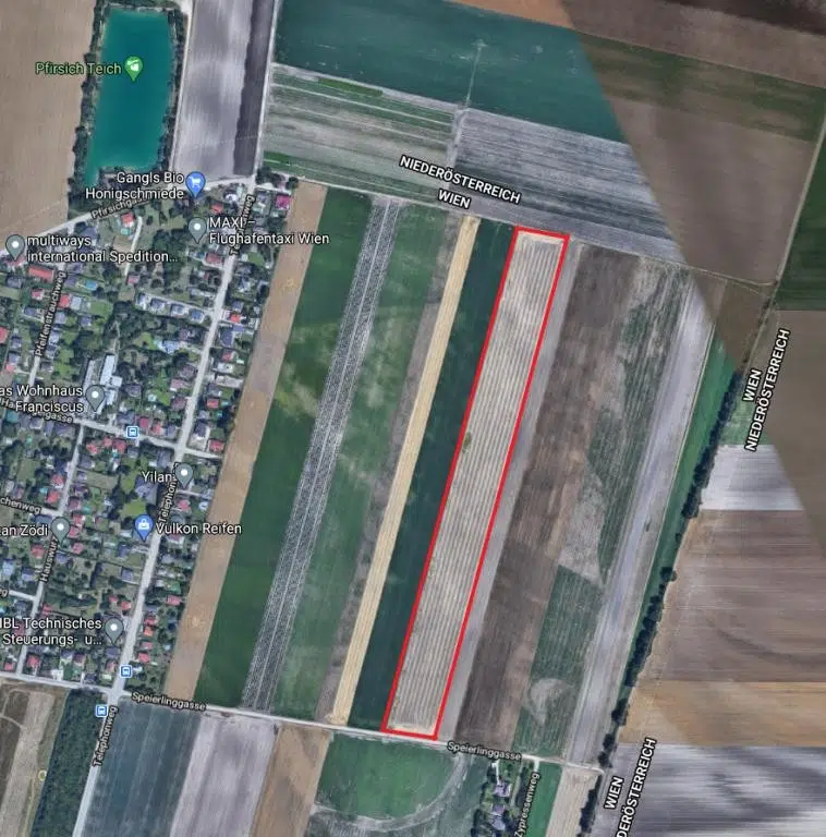 Luftbildaufnahme über den 22. Bezirk von Wien, Felder rechts mit betreffendem Grundstück in roter Umrahmung