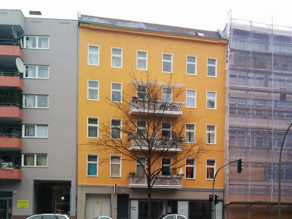 Zinshaus in Berlin, mit oranger Fassade und weißen Fenstern