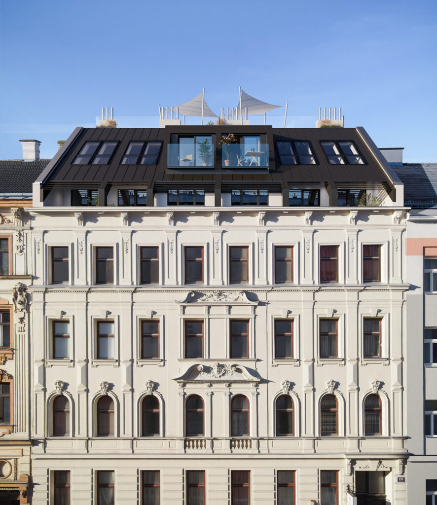 schönes revitalisiertes Zinshaus im 10. Bezirk von Wien, helle Fassade, braune Fenster, Dachausbau mit Terrassen und Balkonen