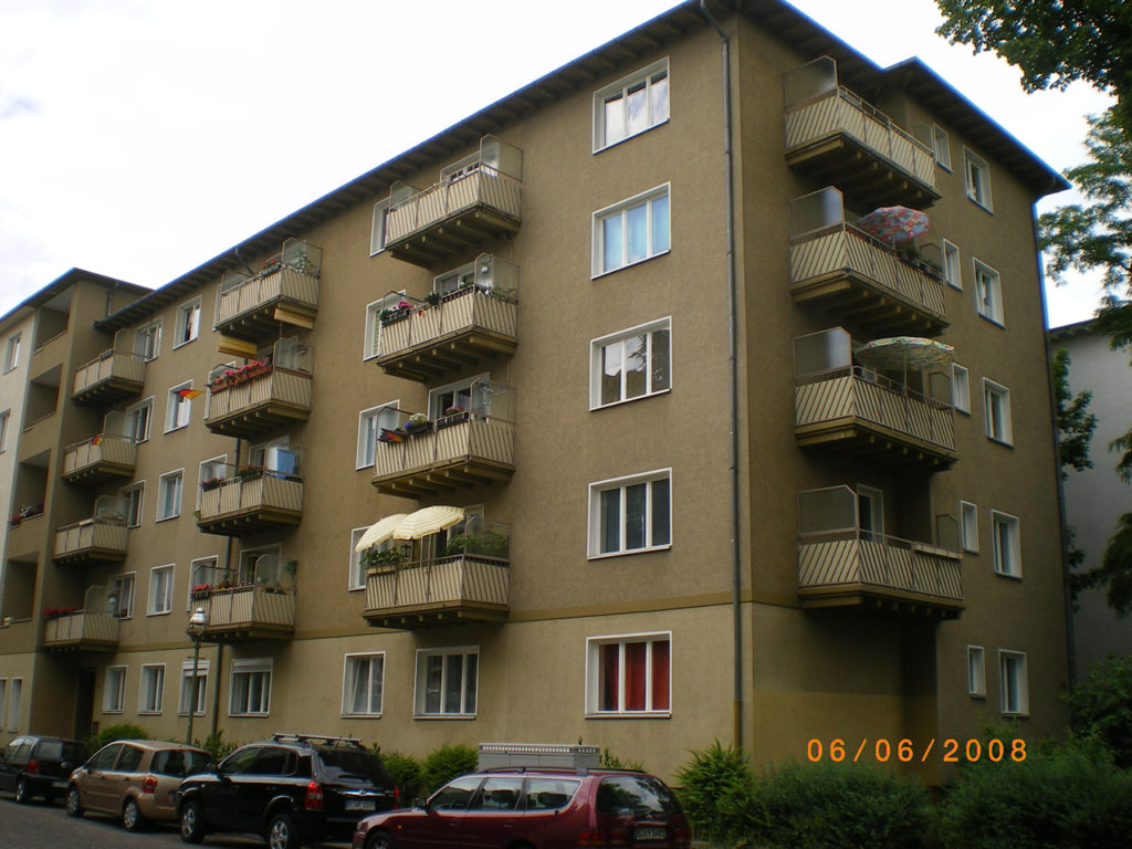 älteres Wohnhaus in Berlin, bräunlich-grüne Fassade mit Balkonen