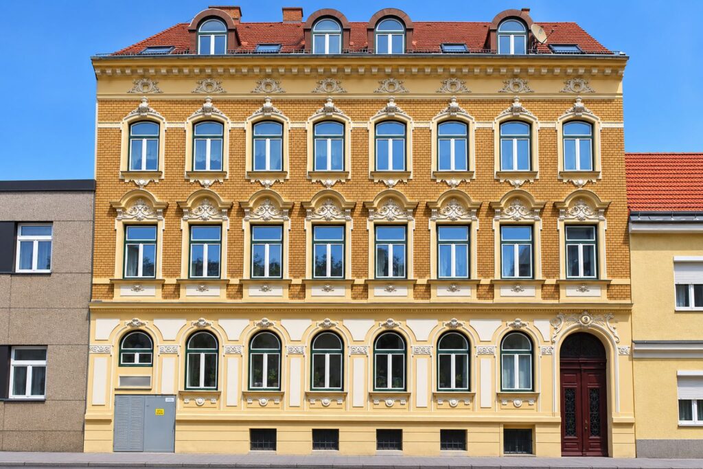 Zinshaus mit gelber Fassade und ziegeloptik