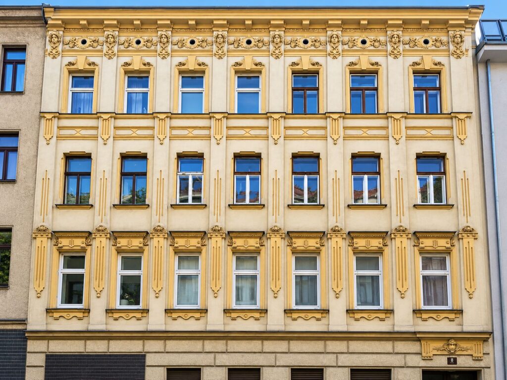 Zinshaus mit gelber Fassade und weißen Fenstern