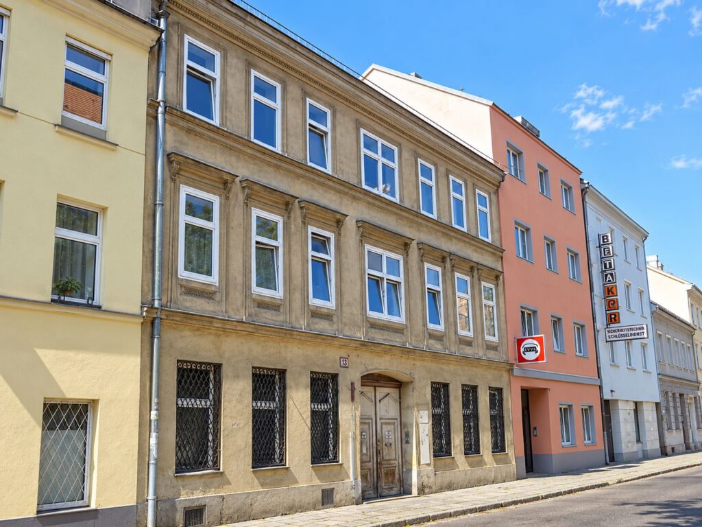 Zinshaus mit weißen Fenster und gelber Fassade