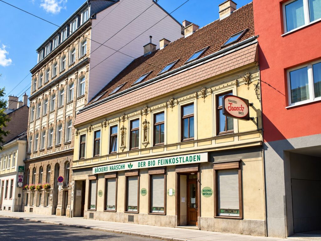altes Zinshaus mit gelber Fassade und braunen Fenster