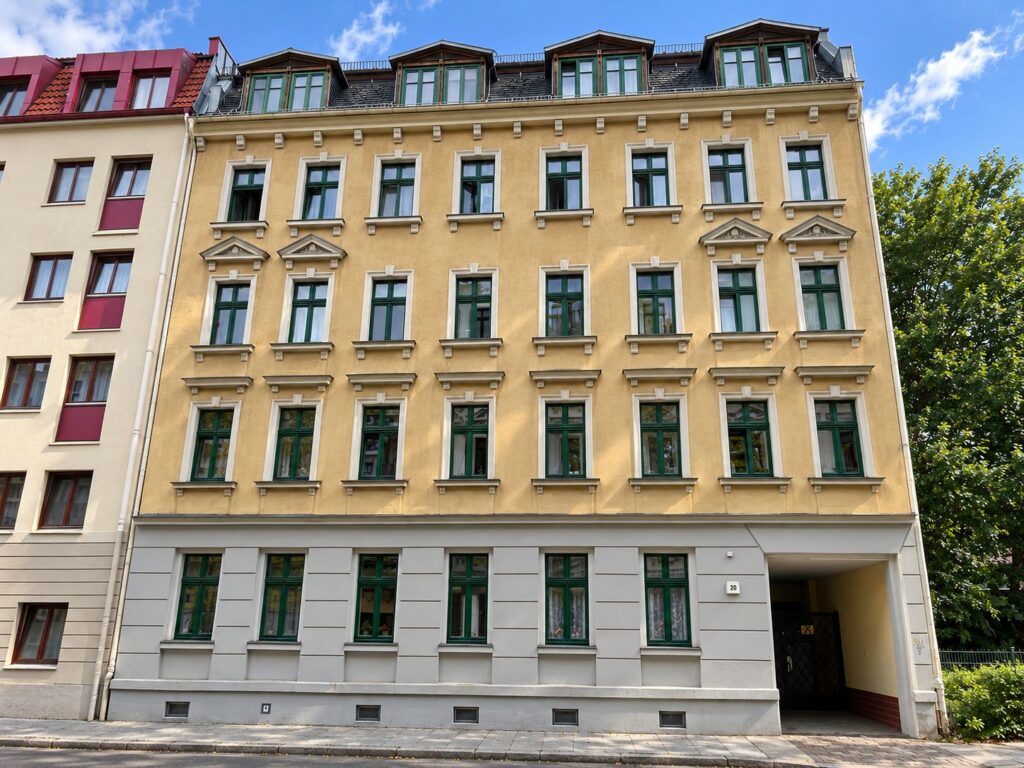 Zinshaus mit gelber Fassade, Fenster grün