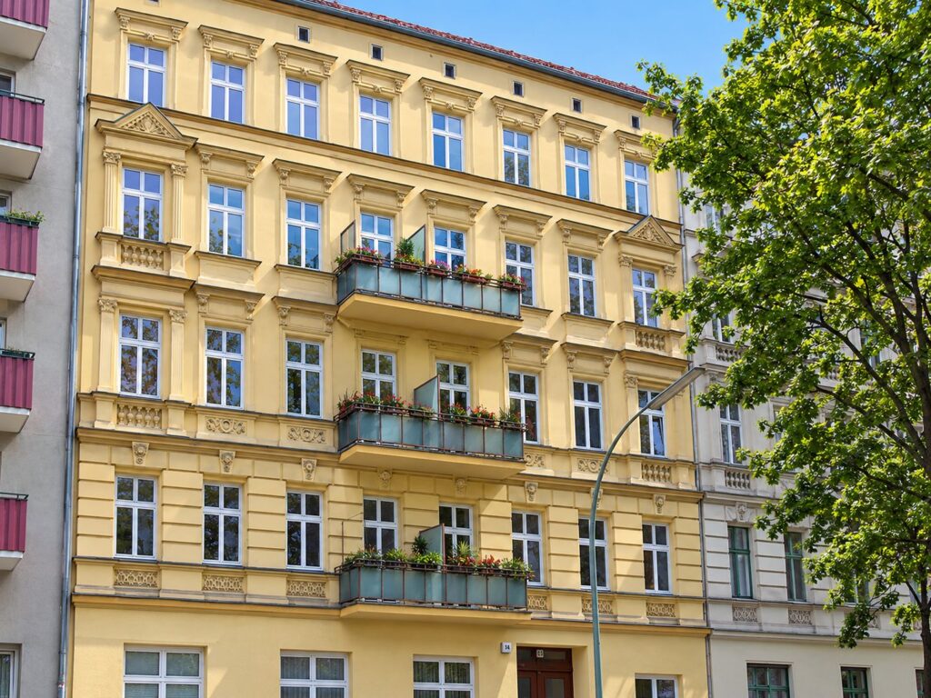 schöner Altbau, gelbe Fassade und 3 Balkonen