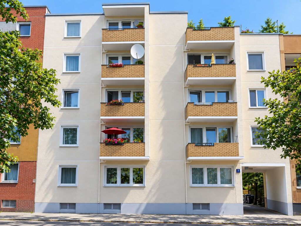 Wohnhausanlage mit cremfarbiger Fassade und Balkonen